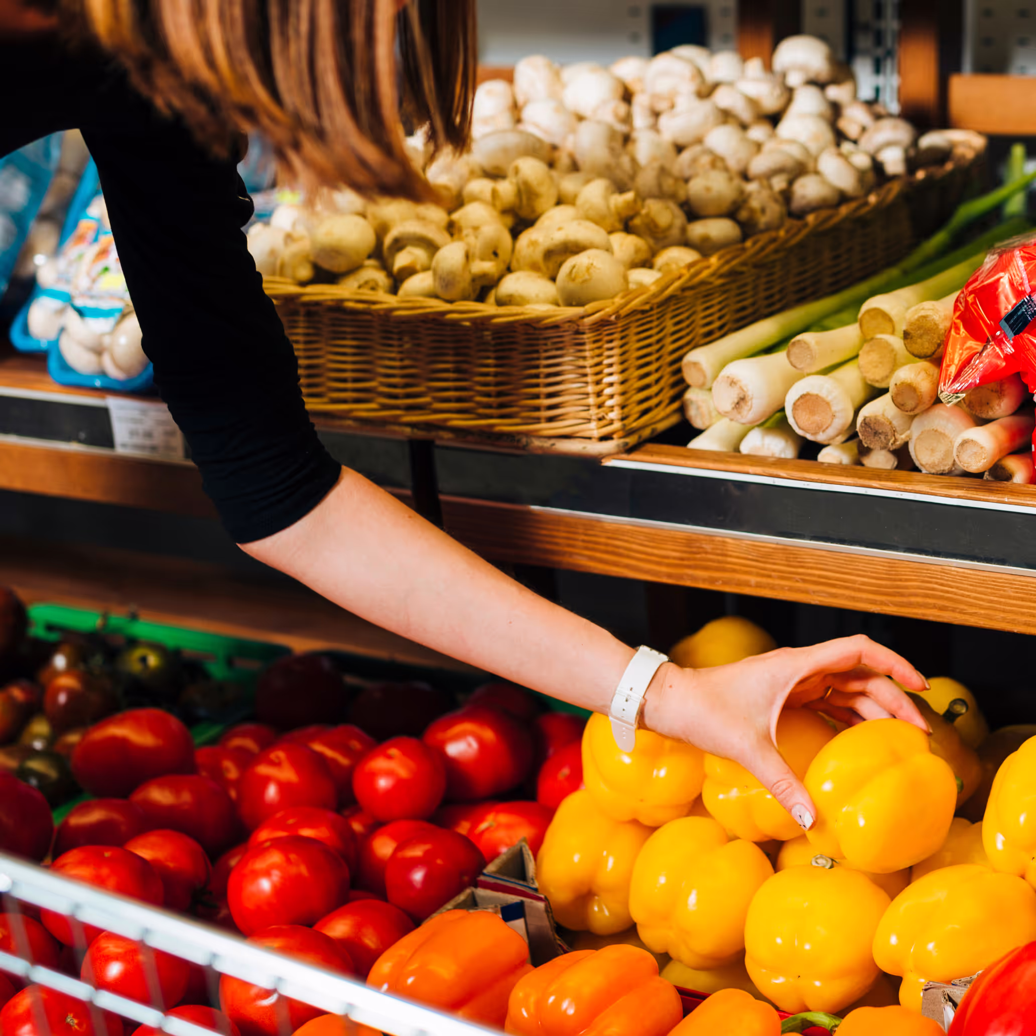 picture of a woman buying peppers at the supermarket