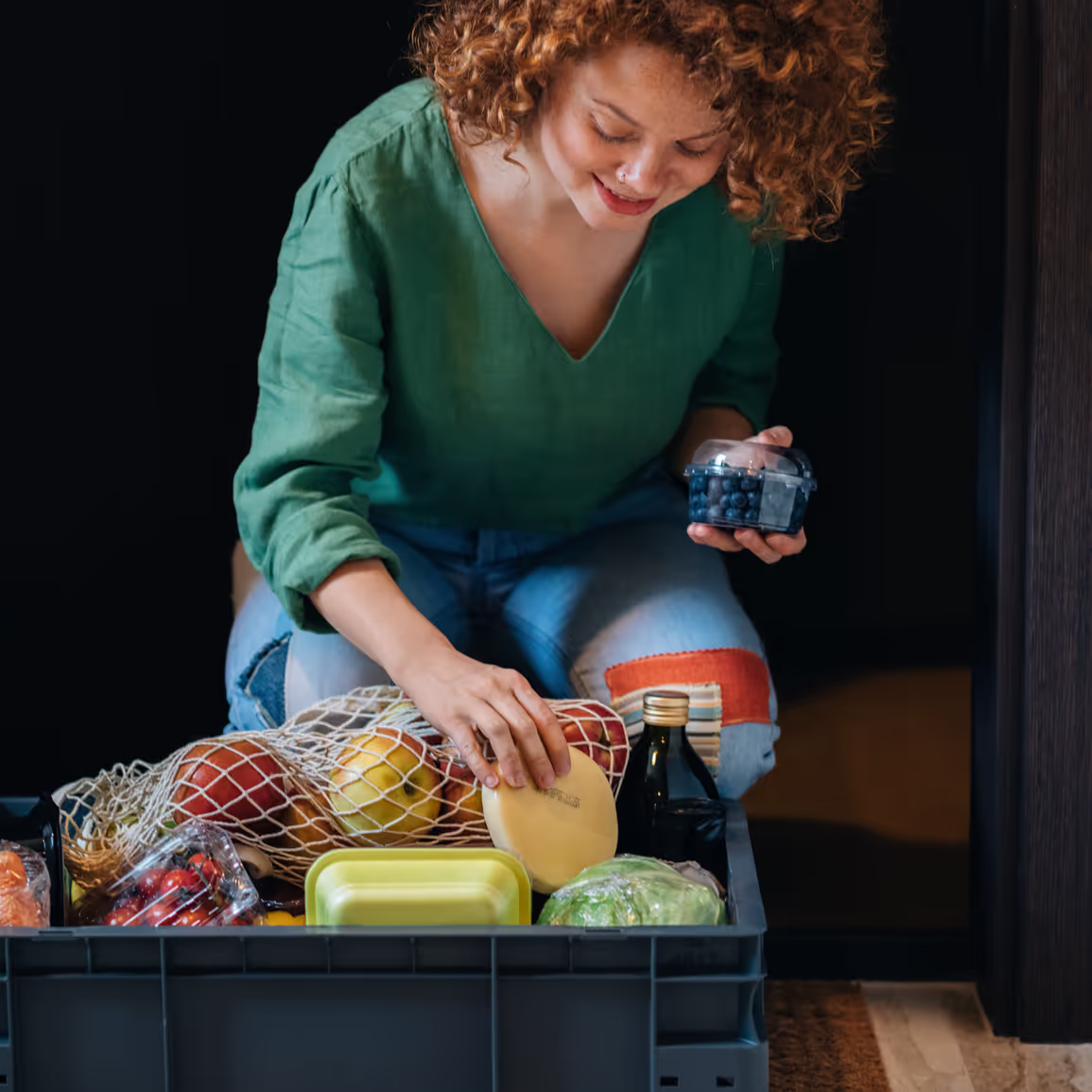 A woman picking up groceries delivered at her house